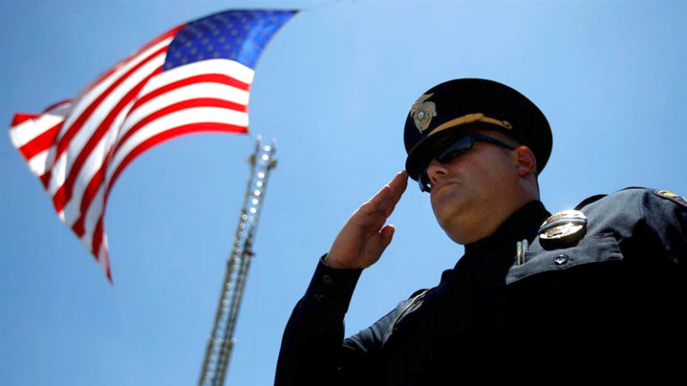 Police Officer Saluting And American Flag